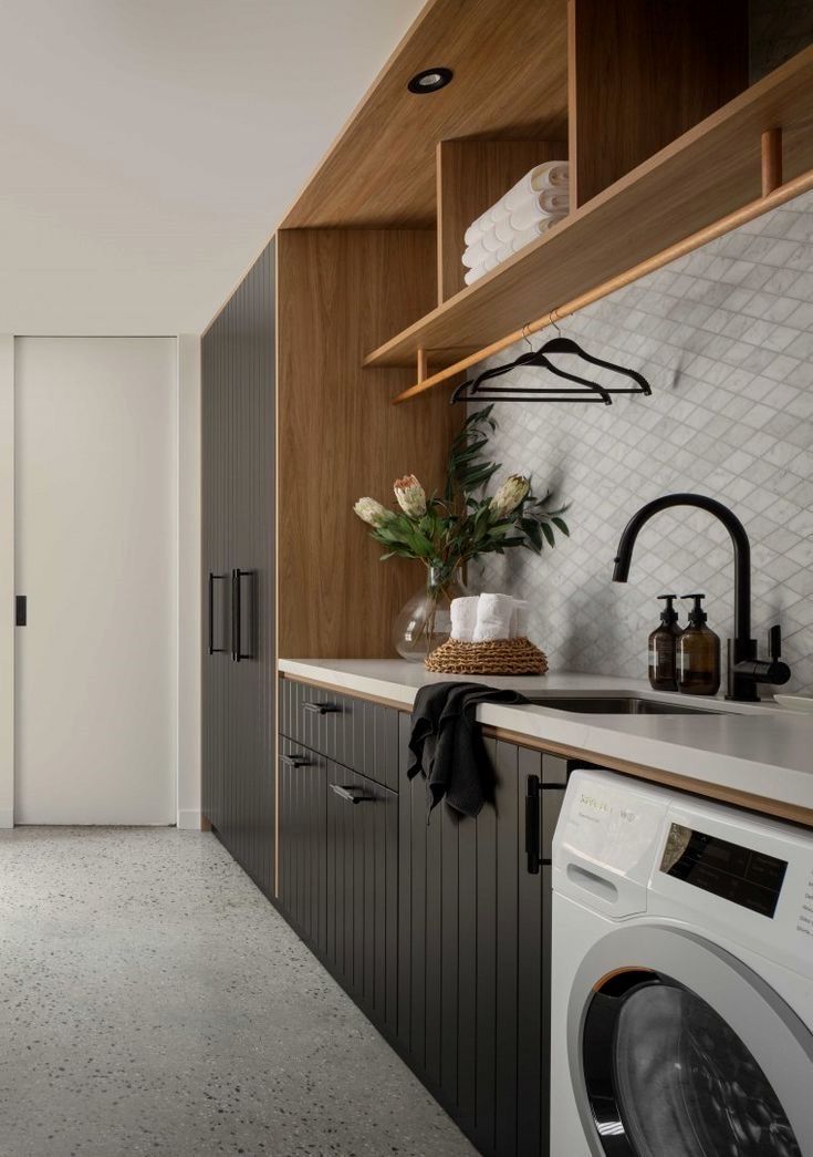 a washer and dryer in a small room next to a wall with shelving