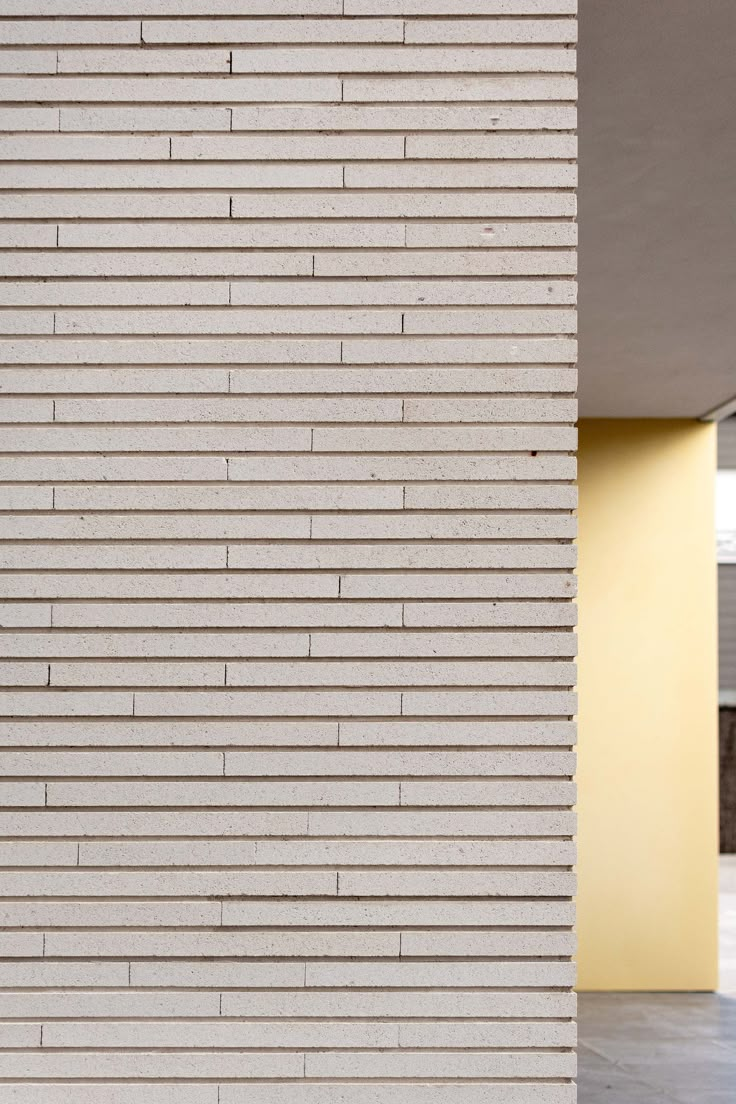 the side of a white building with a clock on it's face and windows