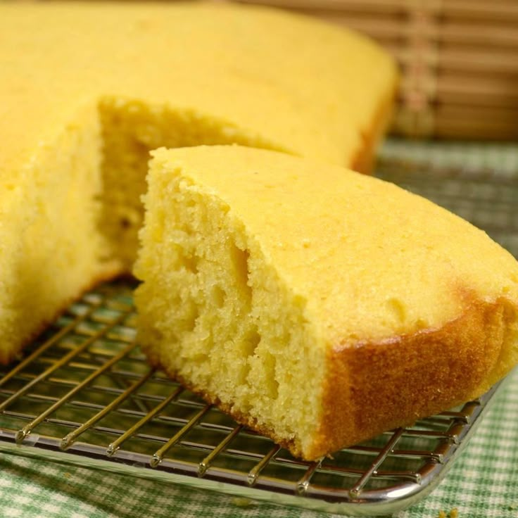 a cake that is sitting on a cooling rack with one slice cut out and ready to be eaten