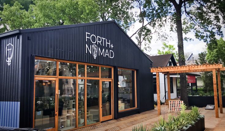 a black building with lots of windows on the outside and some plants in front of it