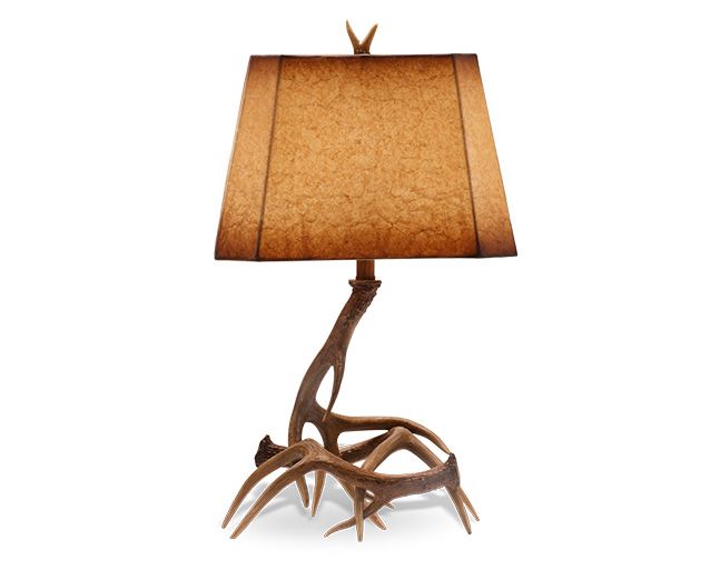 an antler lamp with a brown shade on the base and a light bulb attached to it