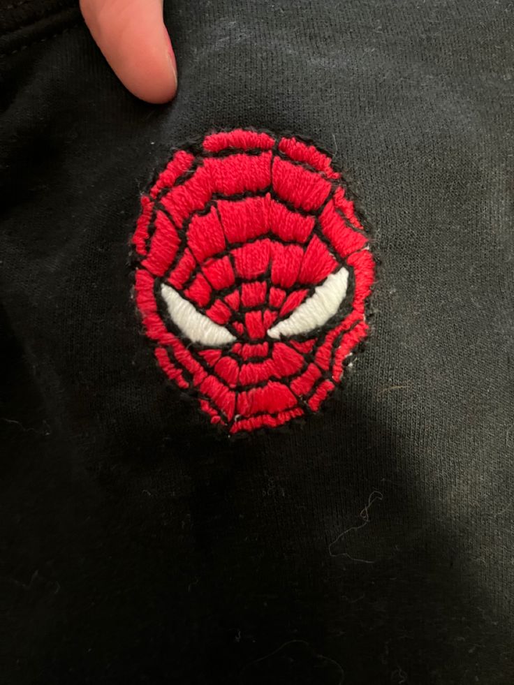 a spiderman patch on the back of a black jacket