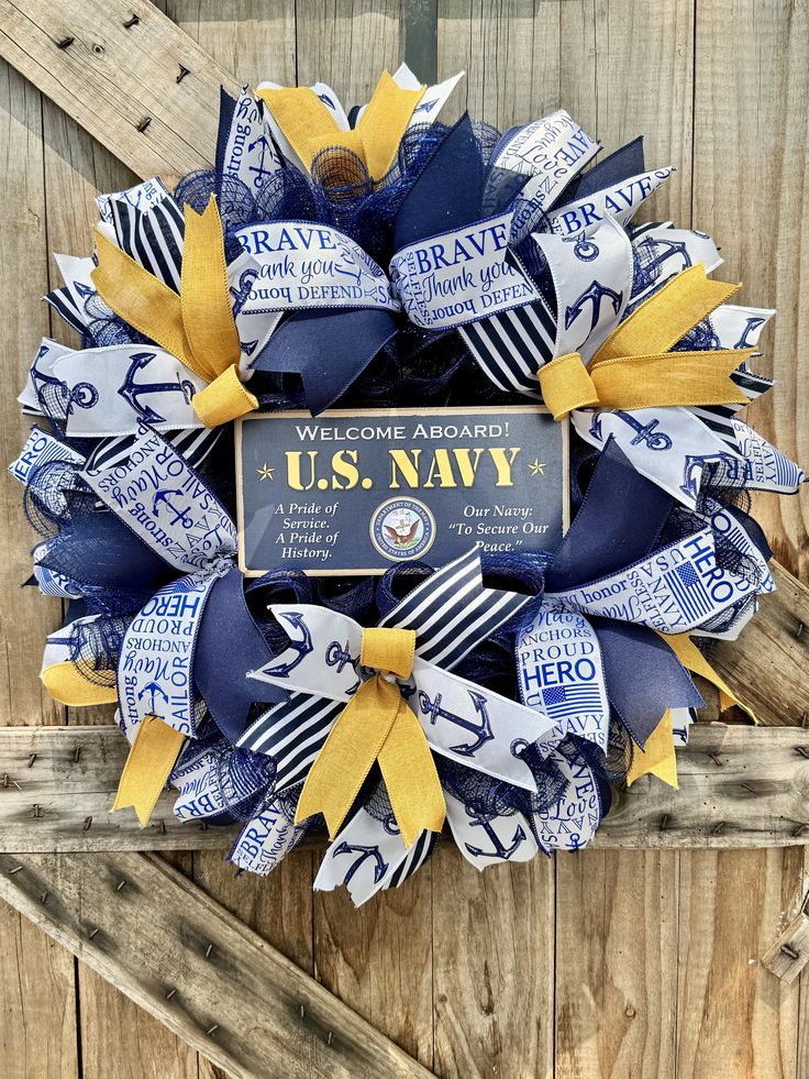 a wreath made out of newspaper strips and ribbons with the u s navy insignia on it