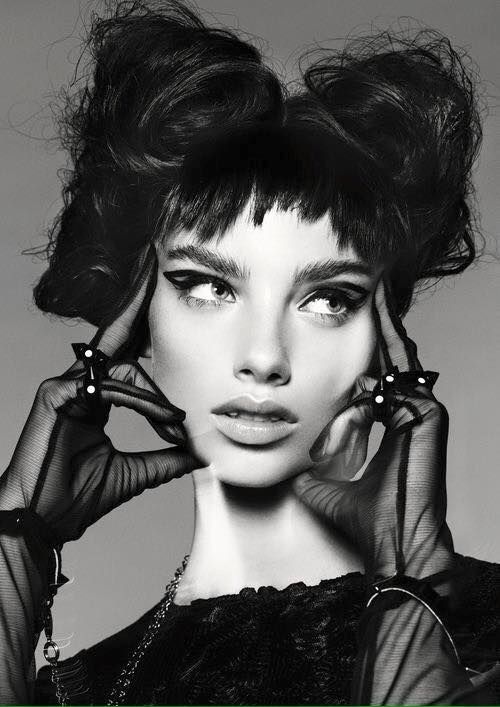 a black and white photo of a woman's face with her hands on her head