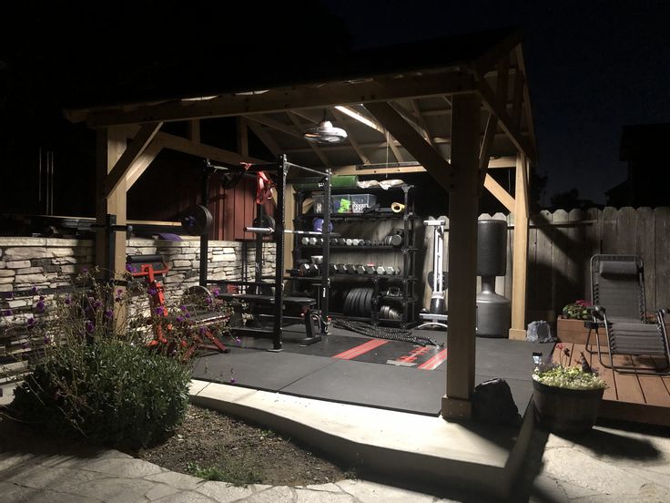 an outdoor gym area lit up at night with lights on and equipment in the background