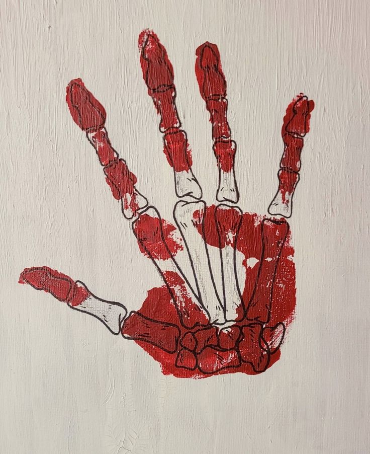 a red handprint on a white wall that has been drawn with crayons