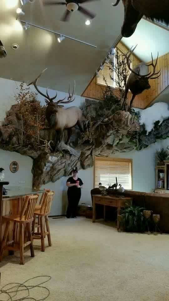 a living room filled with furniture and deer heads on the wall