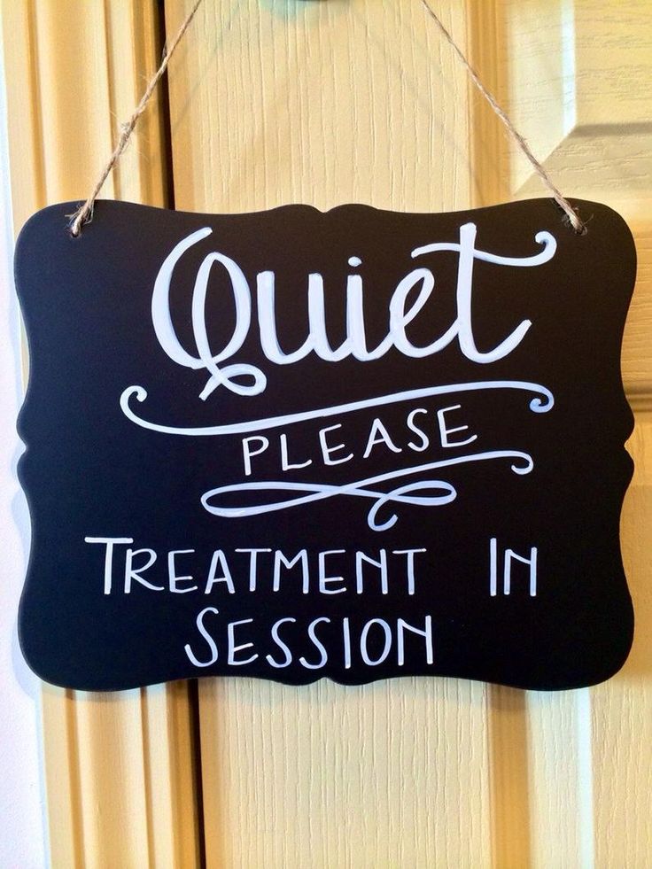 a sign that says quiet please treatment in session hanging on the front door with a clock