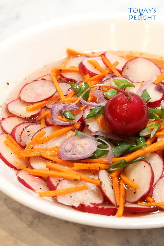 a white plate topped with carrots and radishes