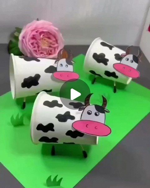 three cows are sitting on green paper with pink flowers