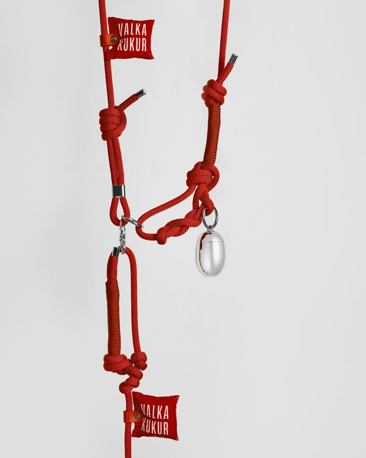 a red rope with two silver hooks attached to it and some tags hanging from the end