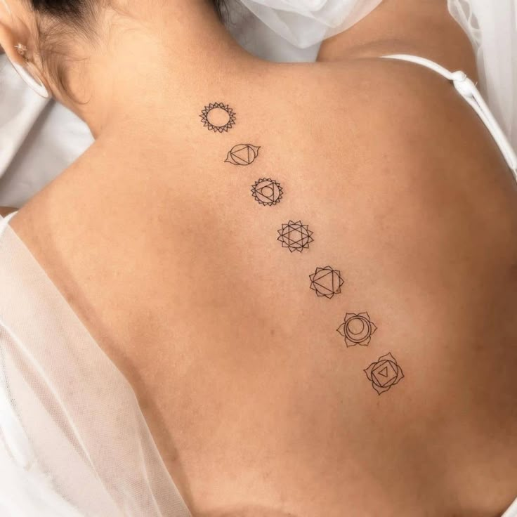 the back of a woman's neck with seven chakras on it