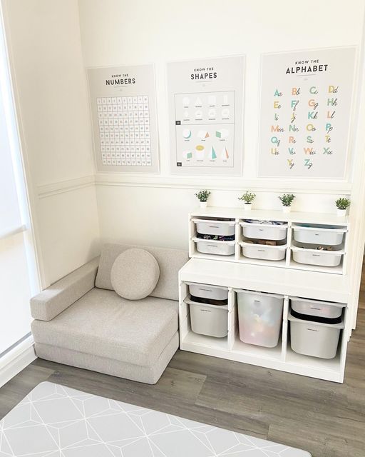 a room with white walls and various storage bins on the wall next to a couch