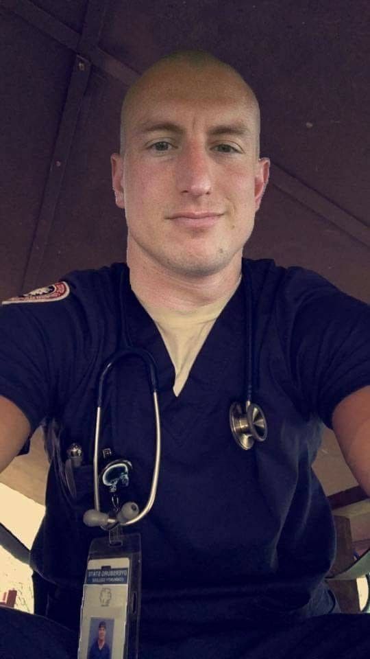 a man with a stethoscope on his neck sitting in front of an umbrella