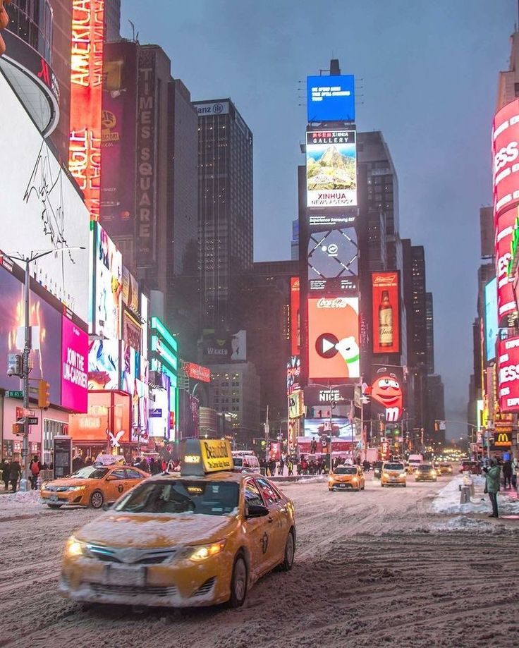 a city street filled with lots of traffic and tall buildings covered in neon colored signs