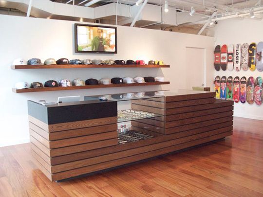 a display case in a store with skateboards on the wall and wooden flooring