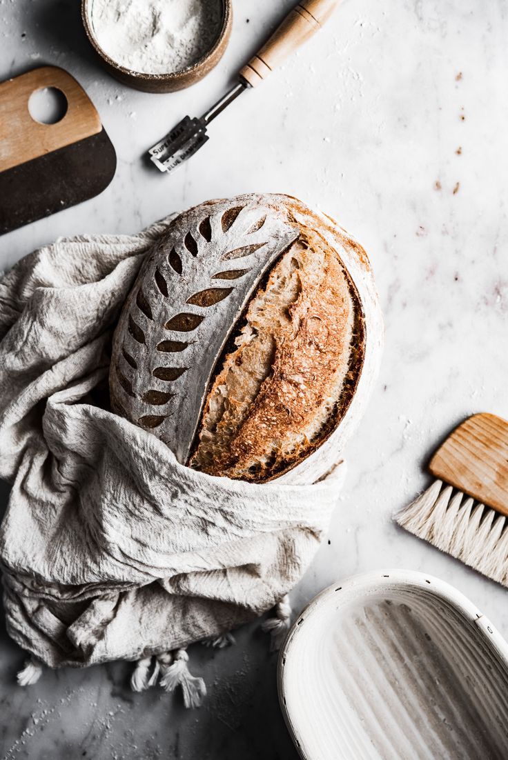 a loaf of bread sitting on top of a table next to other kitchen tools and utensils