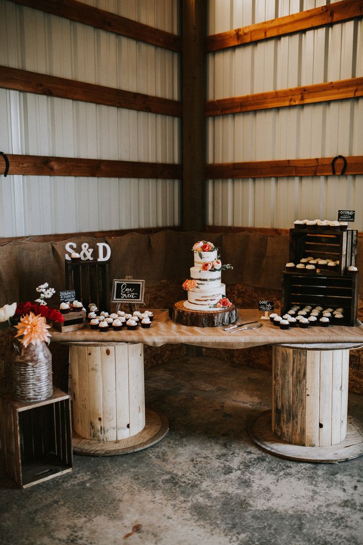 a table topped with cakes and cupcakes on top of wooden tables