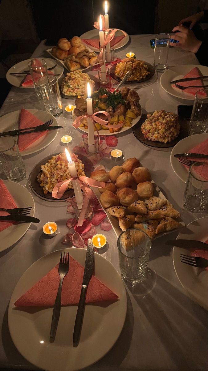 a table set with plates, silverware and candles for a festive dinner party