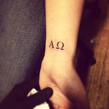 a person with a tattoo on their wrist and the letter qa in black ink