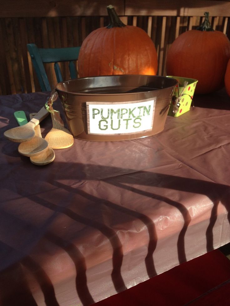 pumpkins sitting on top of a table with a sign that says pumpkin guts in front of them