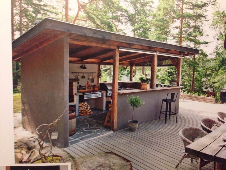 an outdoor kitchen is built into the side of a building with wood floors and walls