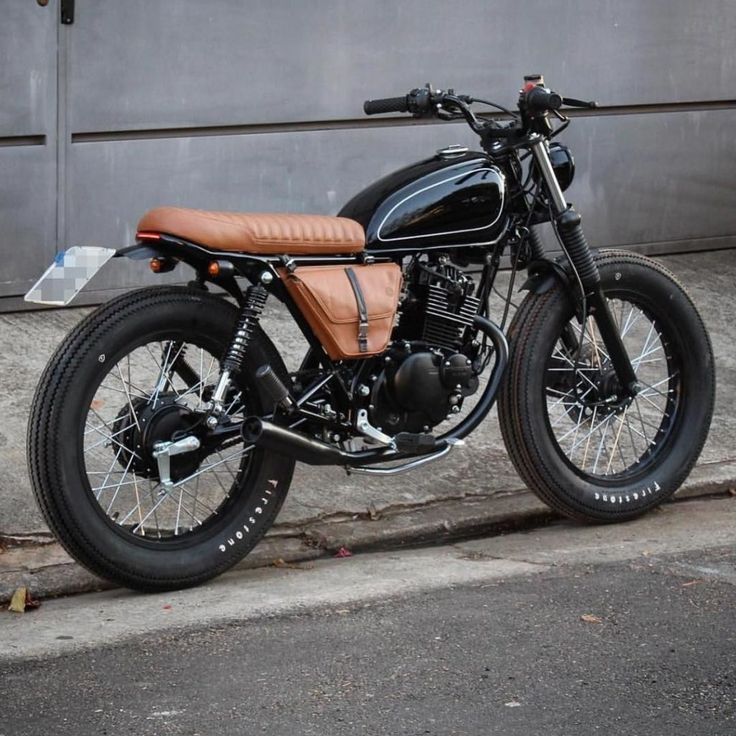 a black and brown motorcycle parked on the street