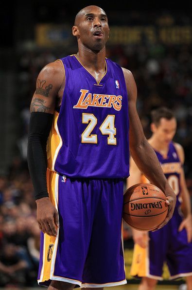 a man holding a basketball in his right hand while standing next to other men on the court