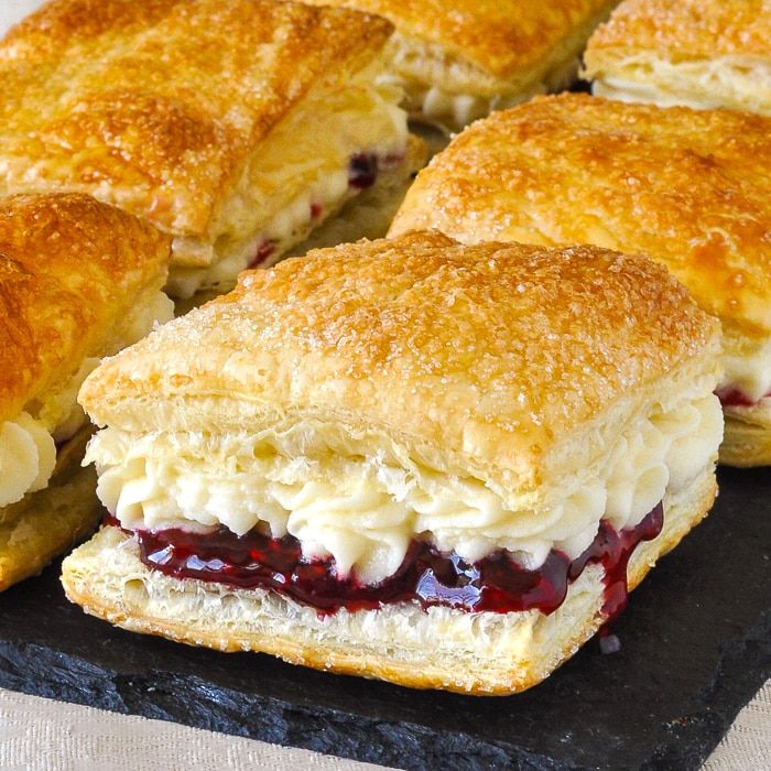 several biscuits and jelly sandwiches on a black plate