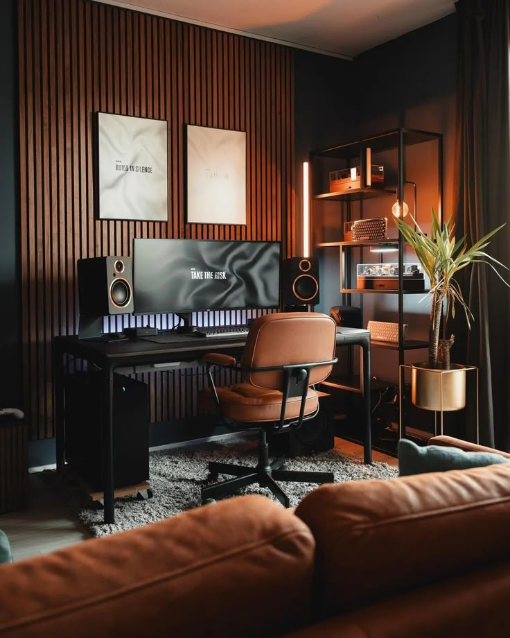 a brown leather chair sitting in front of a computer desk with speakers on top of it