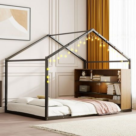 a bed with a house shaped frame and lights on the roof is in a room