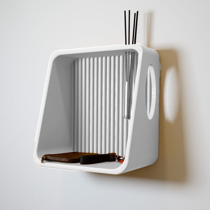 a toothbrush holder on the wall with two black and white sticks sticking out of it