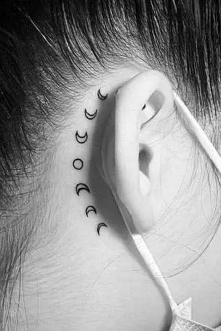 a woman with ear piercings that have the words moon and stars on their ears