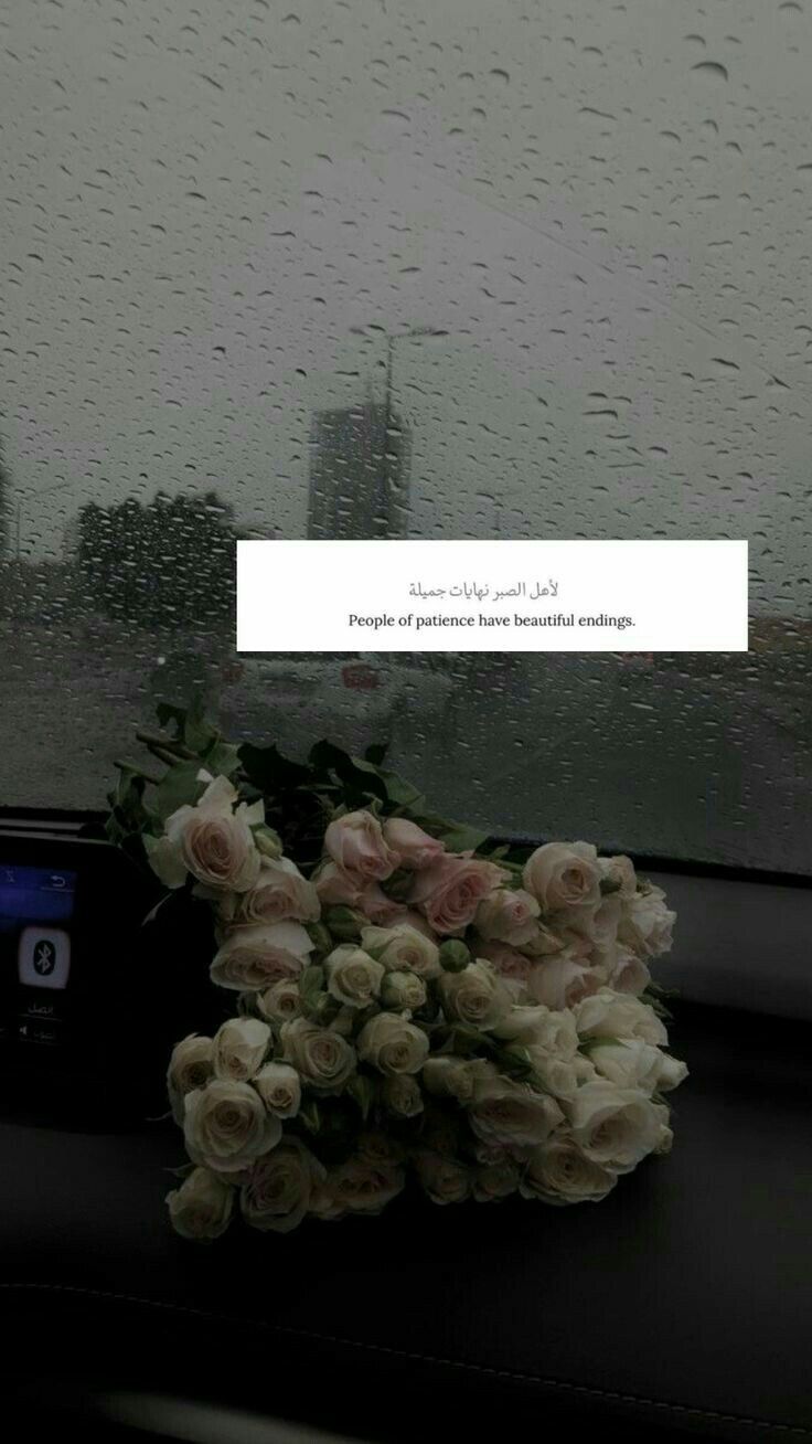 a bouquet of flowers sitting on the dashboard of a car in front of a rain soaked window