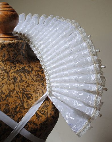 an old fashioned white fan on top of a mannequin