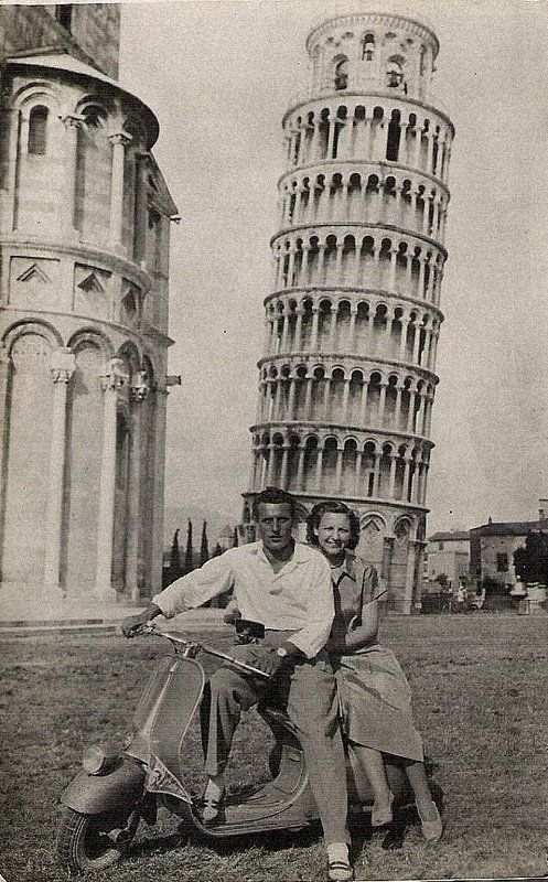 two people on a scooter in front of the leaning tower