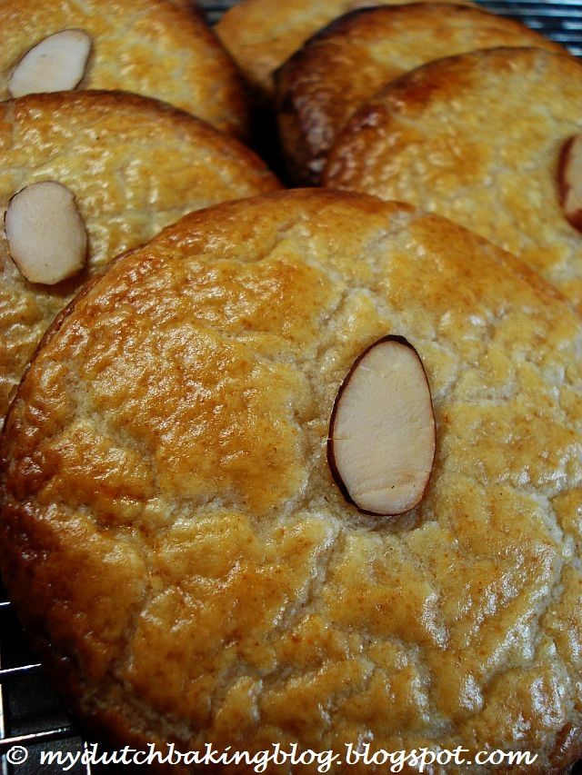 several cookies with almonds are cooling on a rack