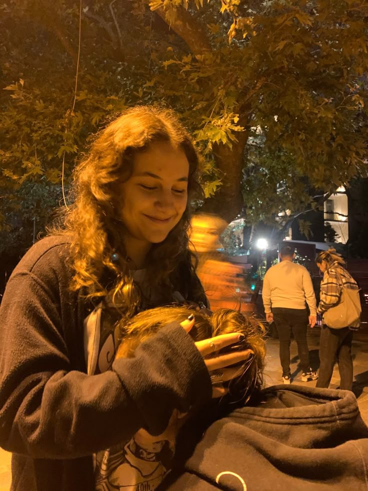 a woman holding a hot dog in her hands