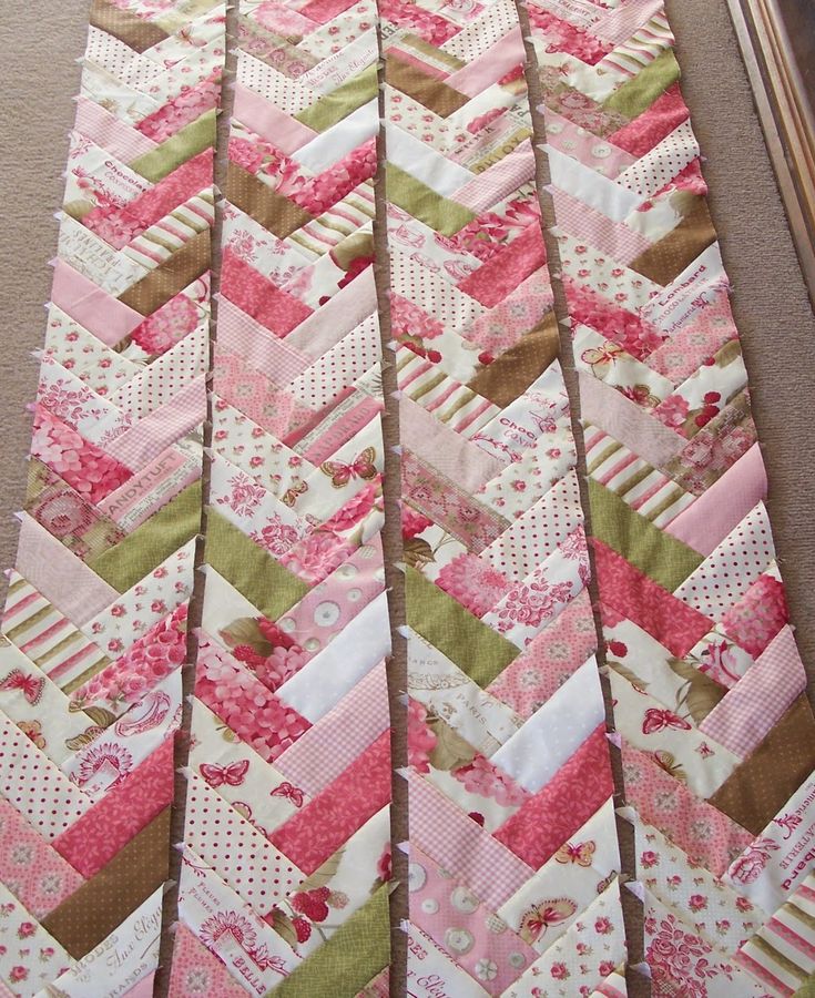 a very pretty pink and green quilt on the floor