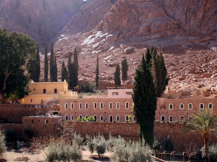 an old building in the desert surrounded by mountains