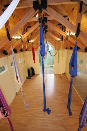 a room with several hammocks hanging from the ceiling