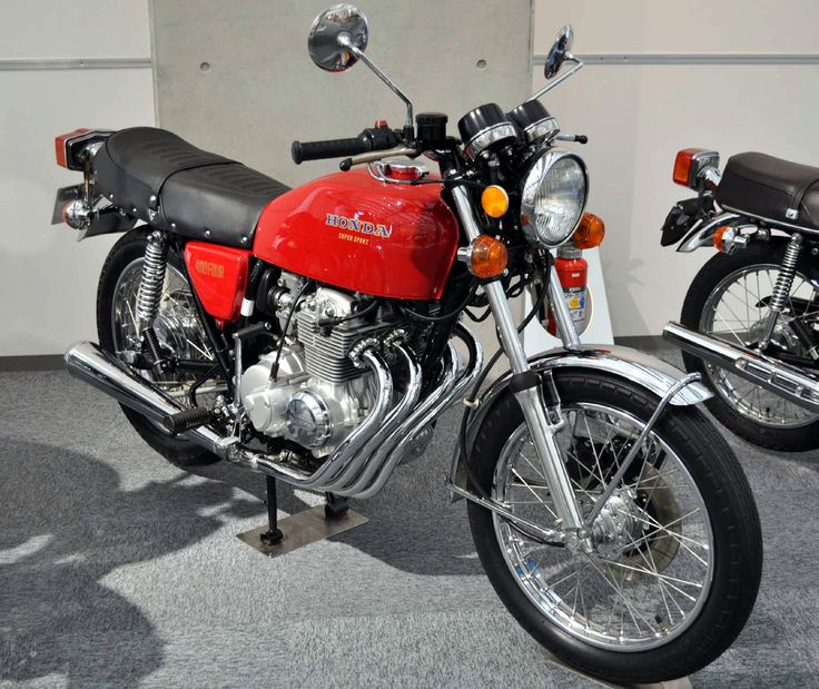 two motorcycles are parked next to each other on the floor in a room with carpeted floors