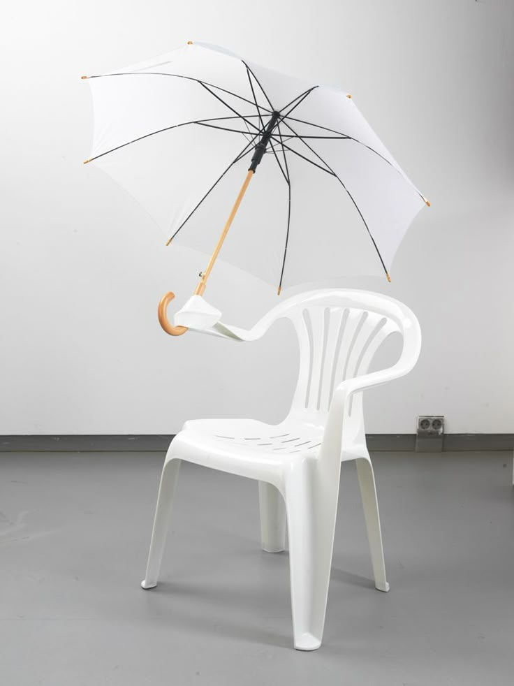 a white chair with an umbrella attached to it