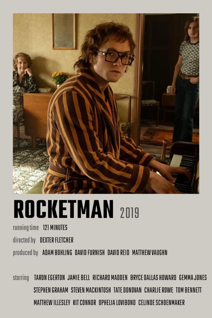 a man sitting at a piano in front of a poster for rockettman 2013