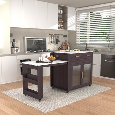 a modern kitchen with white cabinets and wood flooring, along with an island in the middle