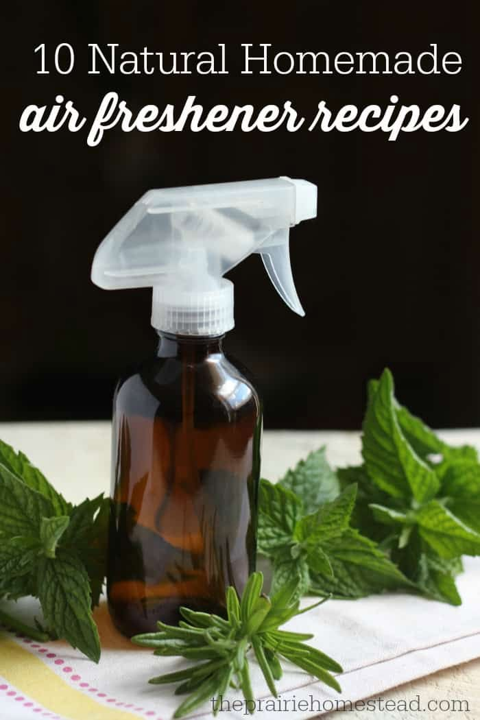 a bottle of air freshener sitting on top of a table next to green leaves