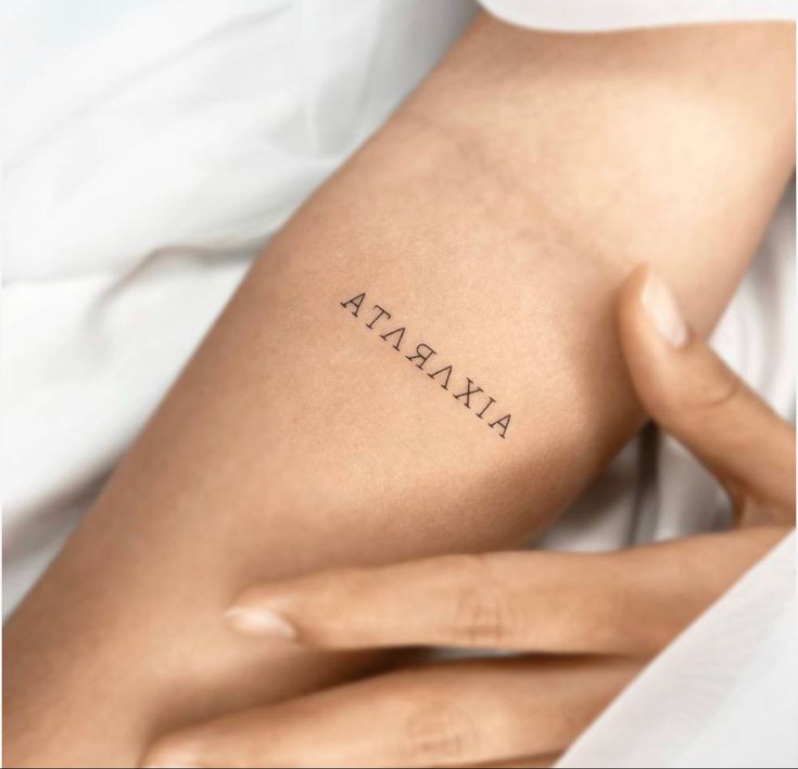 a woman's arm with the word atara tattooed on her left side ribcage