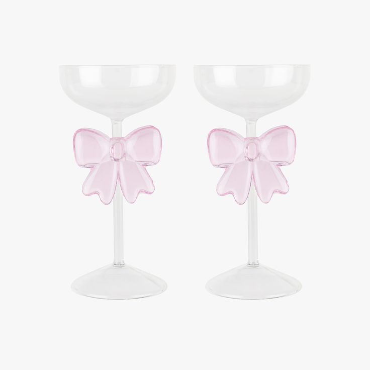 two wine glasses with pink bows on them