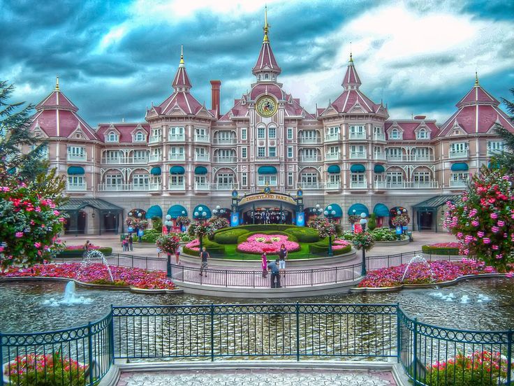 a large pink building with lots of flowers around it