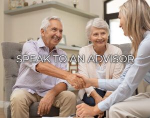 two older people shaking hands while sitting on a couch in front of a woman and man